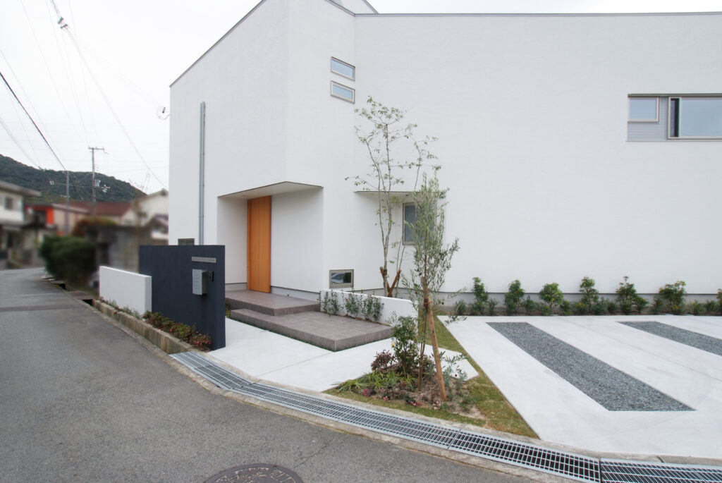 扇型の敷地の外辺に添い、庭を囲むように建物をくの字に配置